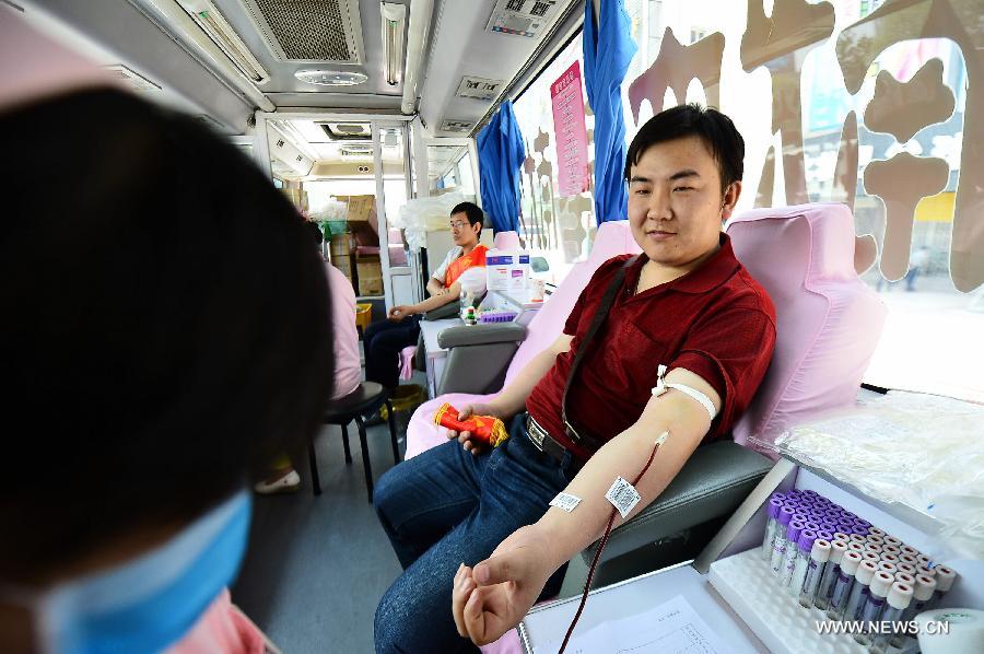 Guo Junpeng, a local citizen, donates blood for free in a mobile blood collection vehicle in Xining, capital of northwest China's Qinghai Province, June 14, 2013, on the occasion of the World Blood Donor Day.