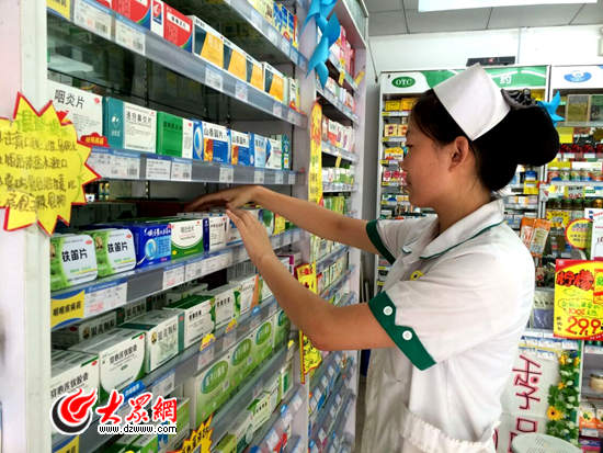 在济南泉城路附近的一家药店内，店员正在整理货架上的药品，1.8元一盒的维C银翘片被放在货架的底层。.jpg
