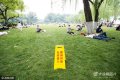 2022-01-25，浙江省杭州市，游客在西湖柳浪闻莺公园大草坪内休息和拍照留影。看着草坪上立着“草坪开放 允许进入”八个字，习惯了多年“不得踏入草坪”的游客们突然有点不适应。