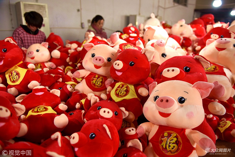 2018年12月13日，山东临沂，沂南县汉街一家玩具企业工人在忙碌着加工“富贵猪”玩具。