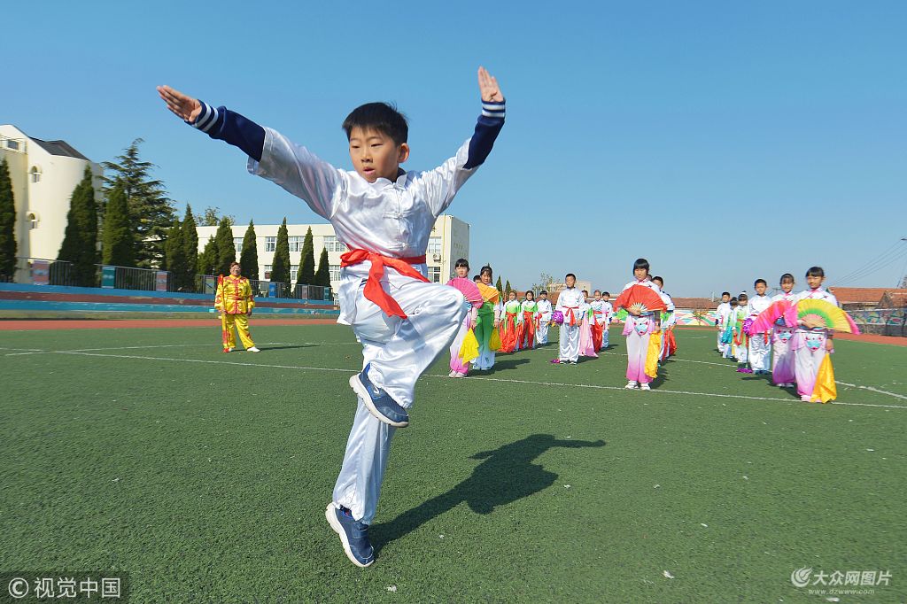 图为青岛郑州路小学的学生在地秧歌表演前展示武术技艺.