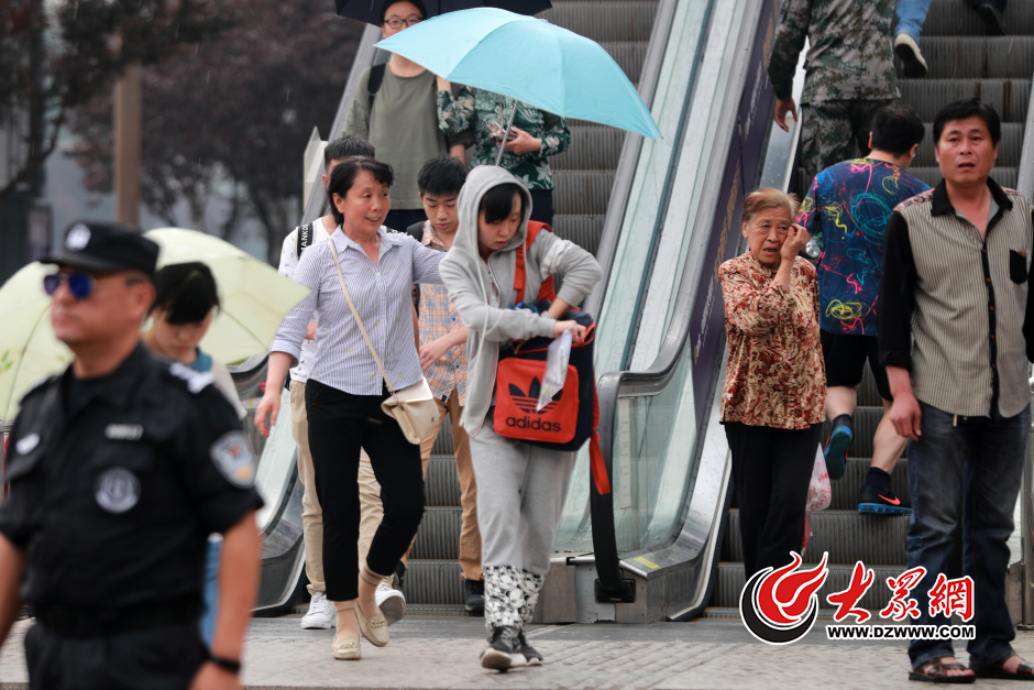 6月7日下午，高考第一天，济南下起了小雨，在山东省实验中学考点外，一家长打着伞送考。大众网记者 王长坤 摄