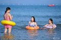 2018年5月31日，众多游客来到山东青岛西海岸新区金沙滩海水浴场，体验初夏时节的海边沙滩风情，还有部分游客等不及海水温度上升率先下到海水中尝鲜游泳带来的快乐。