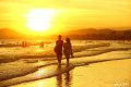 2019年6月6日，海南三亚，一对情侣在三亚湾海边落日余晖中散步。